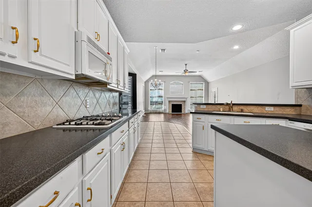 a kitchen with stainless steel appliances granite countertop a stove a sink and a microwave