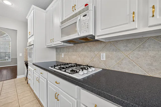 a kitchen with granite countertop a stove and a microwave