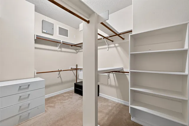 a view of walk in closet with empty racks