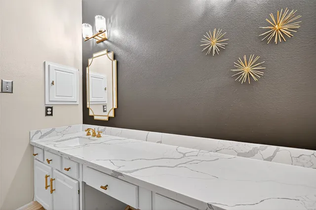 a bathroom with a sink vanity and a mirror