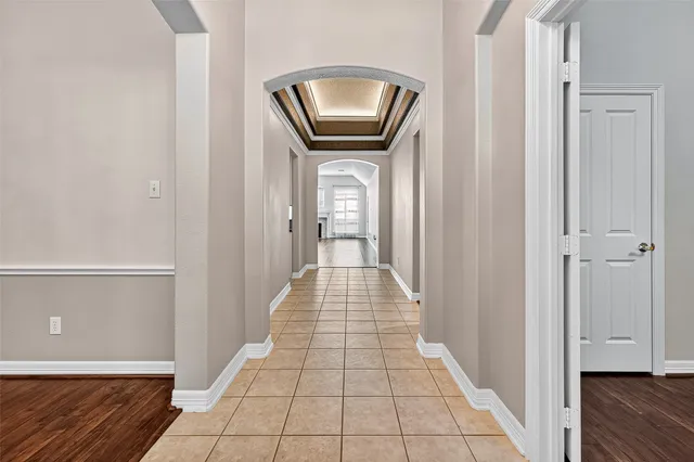 a view of a hallway with wooden floor and a living room