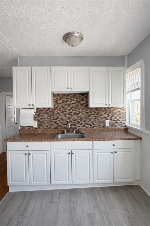 159 Frederick Street, Unit 3E New Bedford, MA 02744 - Photo 4 of 8 a kitchen with granite countertop white cabinets and sink