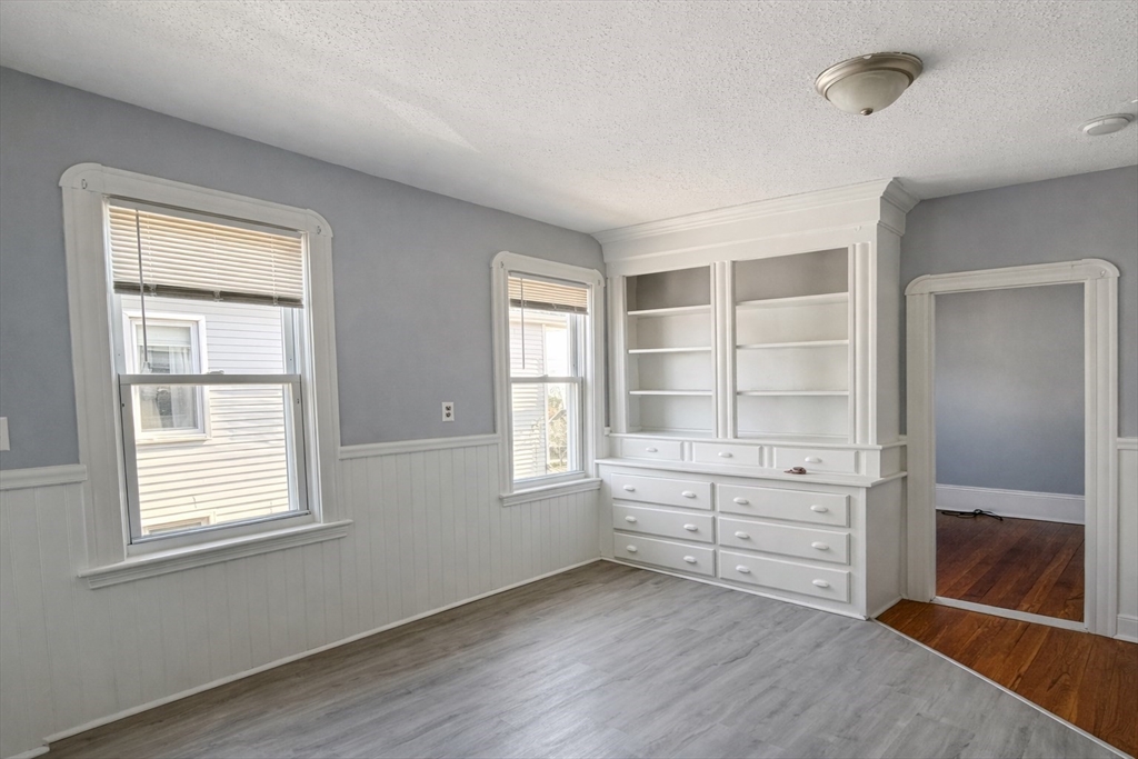 159 Frederick Street, Unit 3E New Bedford, MA 02744 - Photo 5 of 8 an empty room with cabinet and windows