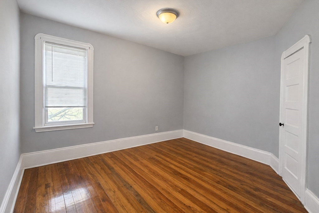 159 Frederick Street, Unit 3E New Bedford, MA 02744 - Photo 6 of 8 a view of an empty room with wooden floor and a window