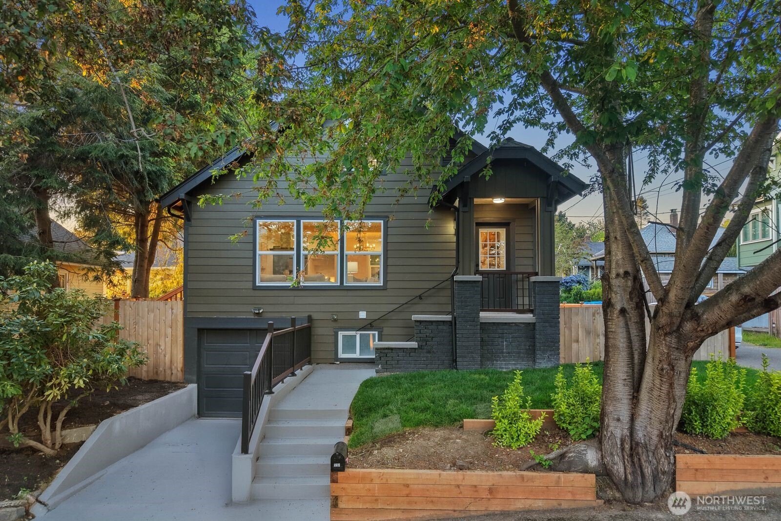 a front view of a house with a tree