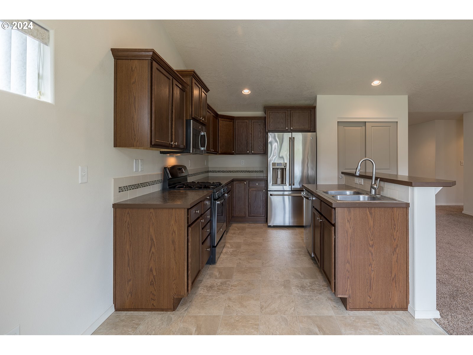 941 South 55th Street Springfield, OR 97478 - Photo 12 of 24 a kitchen with stainless steel appliances granite countertop a stove a sink and a refrigerator