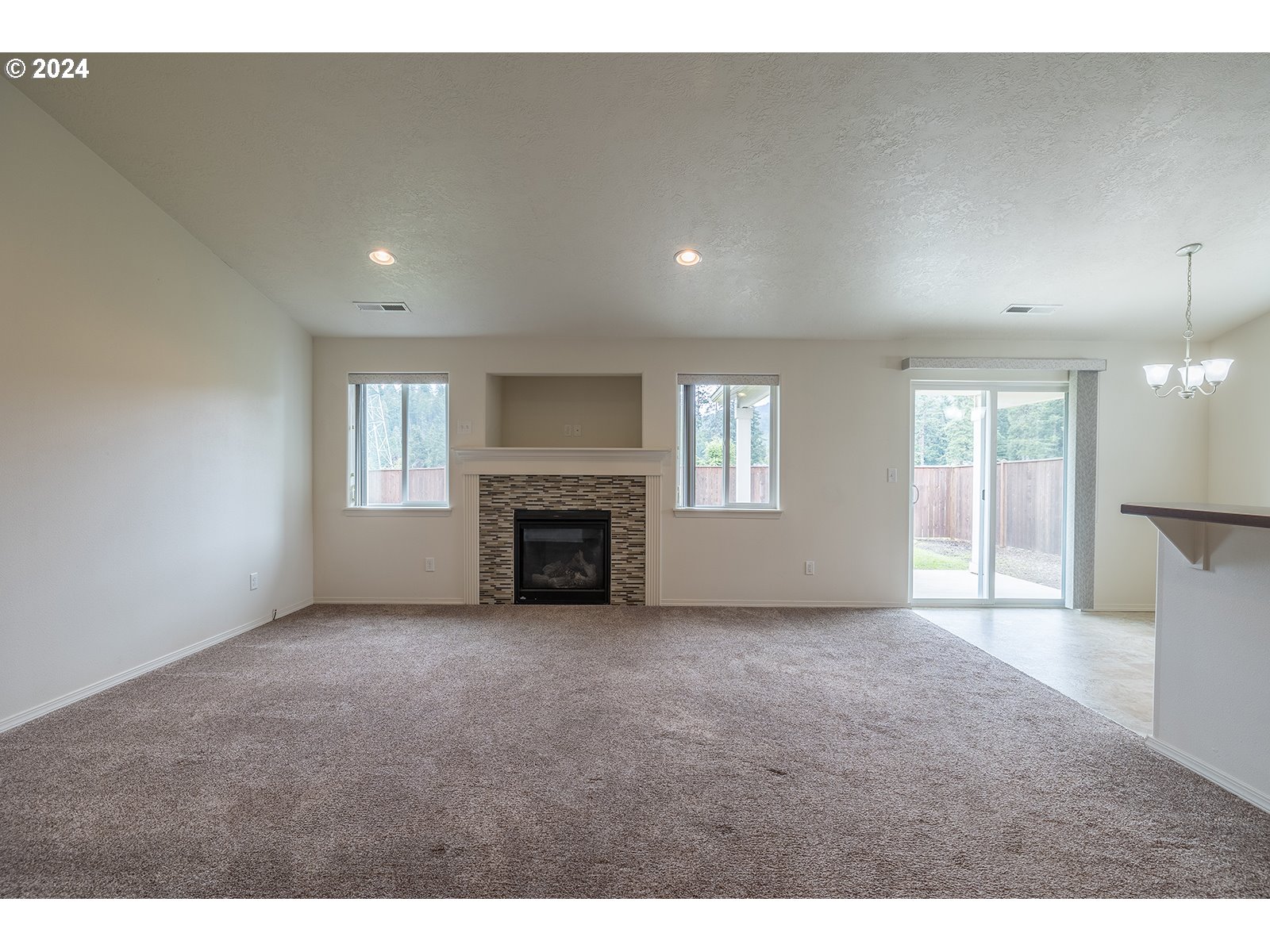 941 South 55th Street Springfield, OR 97478 - Photo 6 of 24 a view of an empty room with a fireplace and a window