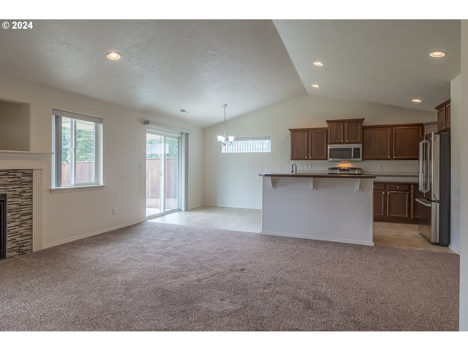 941 South 55th Street Springfield, OR 97478 - Photo 7 of 24 a view of kitchen with kitchen island a sink wooden floor and a refrigerator