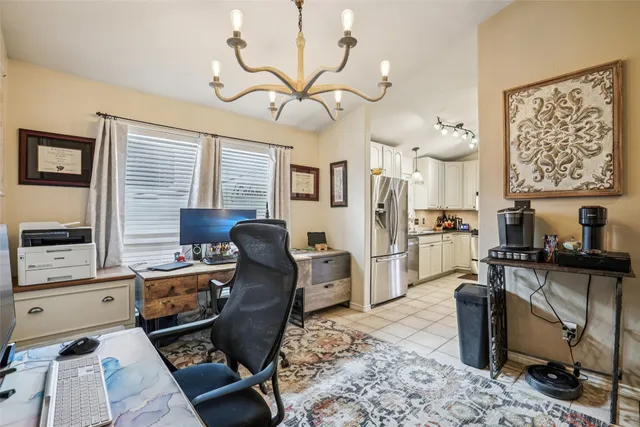 a view of a workspace with furniture and a window