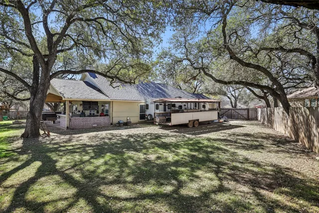 a view of a back yard of the house with a table and chairs