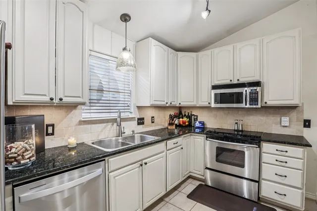 a kitchen with stainless steel appliances a sink cabinets and a refrigerator