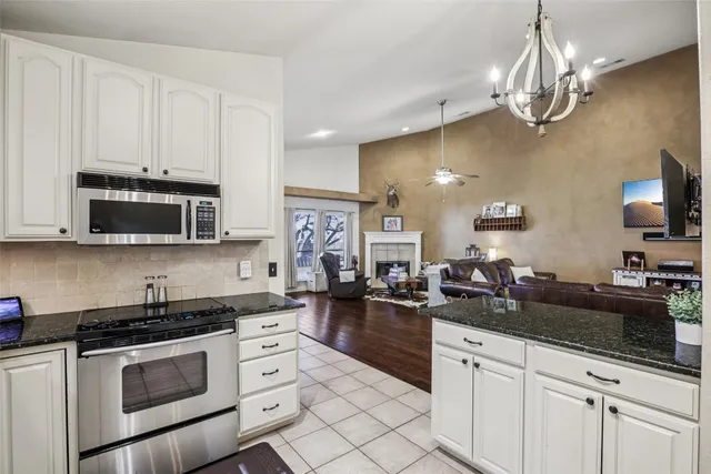 a kitchen with stainless steel appliances granite countertop white cabinets and a sink