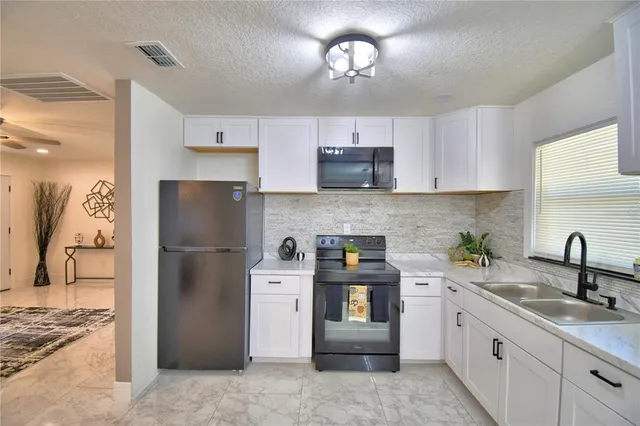 a kitchen with a sink a refrigerator and cabinets