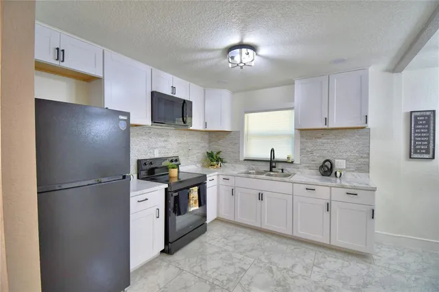 a kitchen with stainless steel appliances granite countertop a refrigerator sink and cabinets