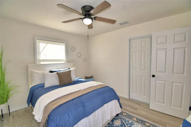a bedroom with a large bed and a chandelier