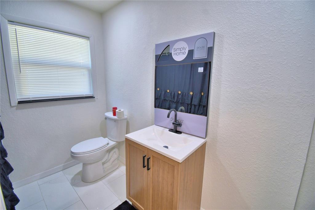 6960 2nd Street Mulberry, FL 33860 - Photo 32 of 39 a bathroom with a toilet sink and mirror