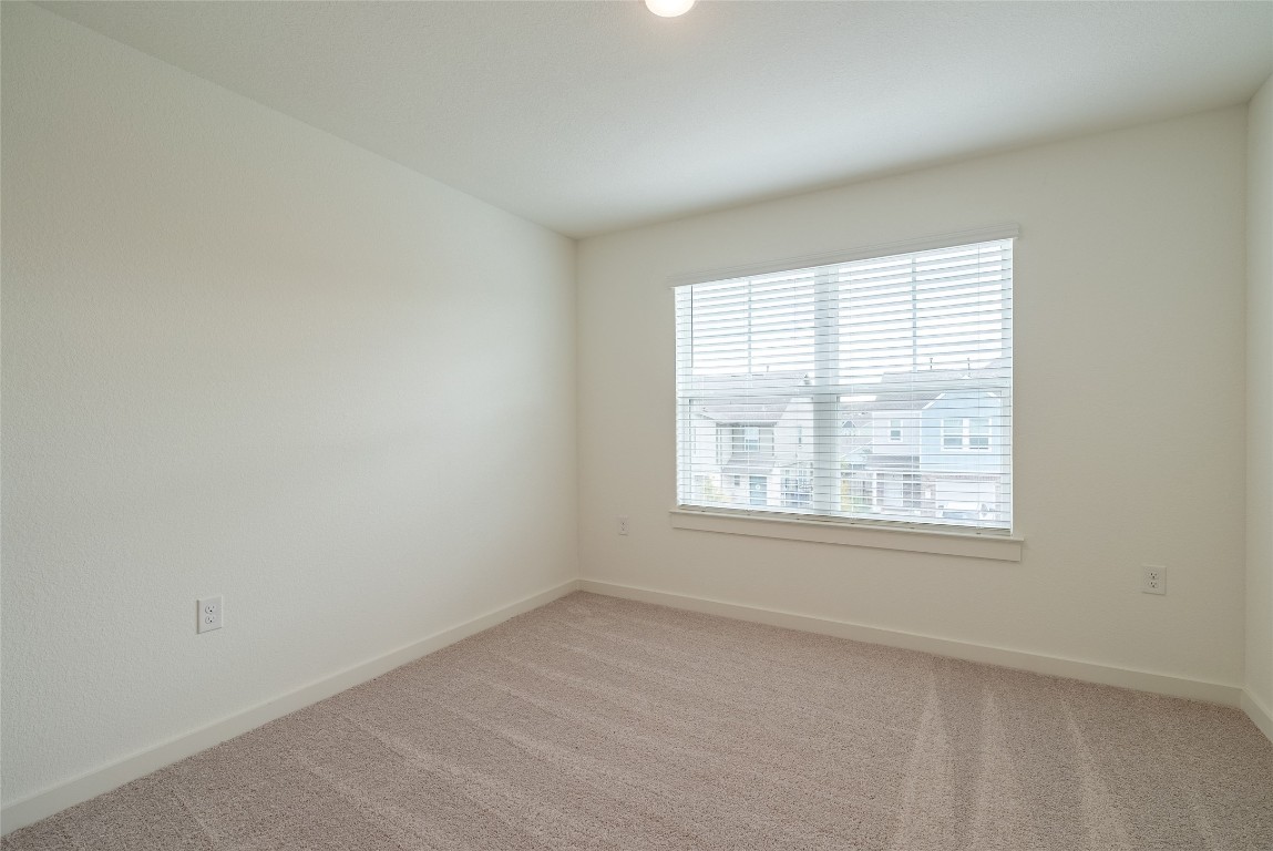 7400 Sparkling Light Drive, Unit A Del Valle, TX 78617 - Photo 11 of 22 Spare room with light carpet and baseboards