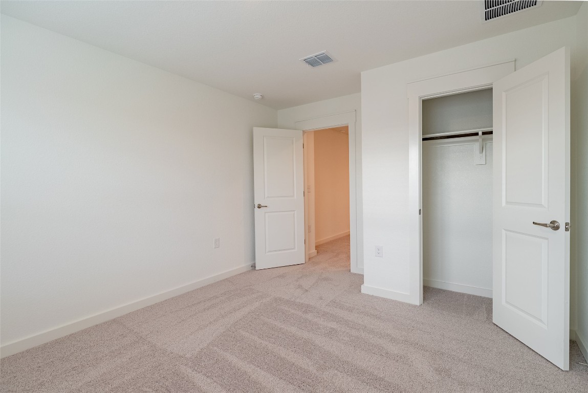 7400 Sparkling Light Drive, Unit A Del Valle, TX 78617 - Photo 12 of 22 Unfurnished bedroom featuring light colored carpet and a closet
