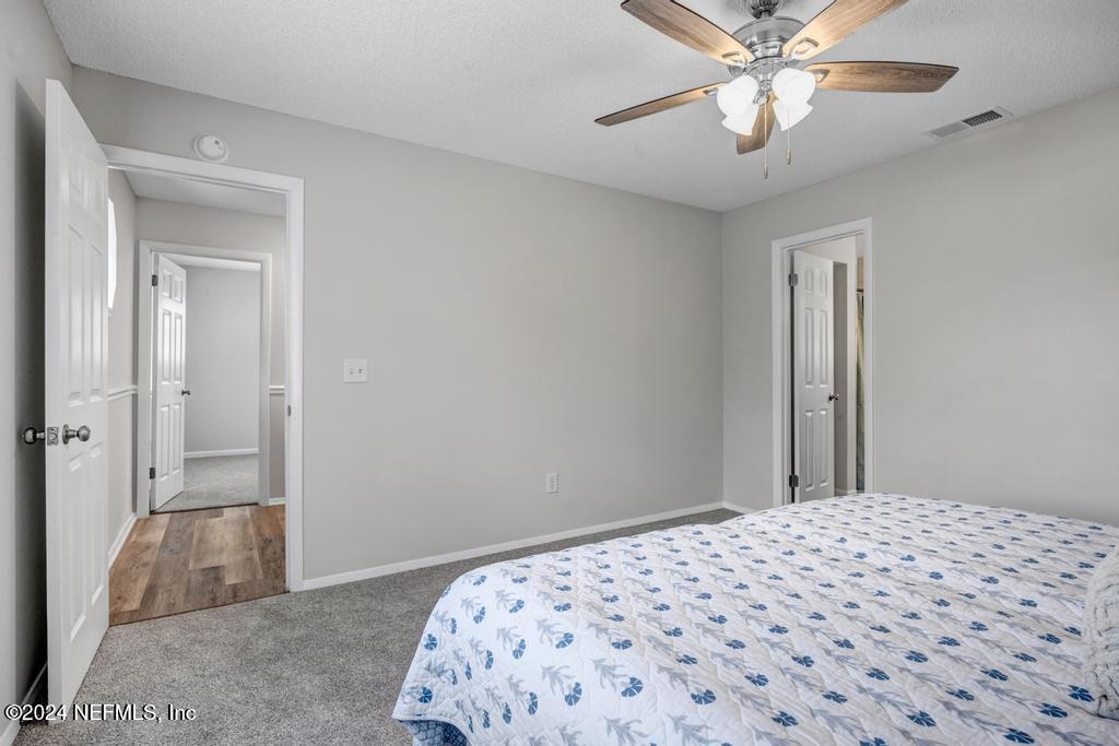 54197 Jeannie Road Callahan, FL 32011 - Photo 22 of 36 a bedroom with a bed and a chandelier