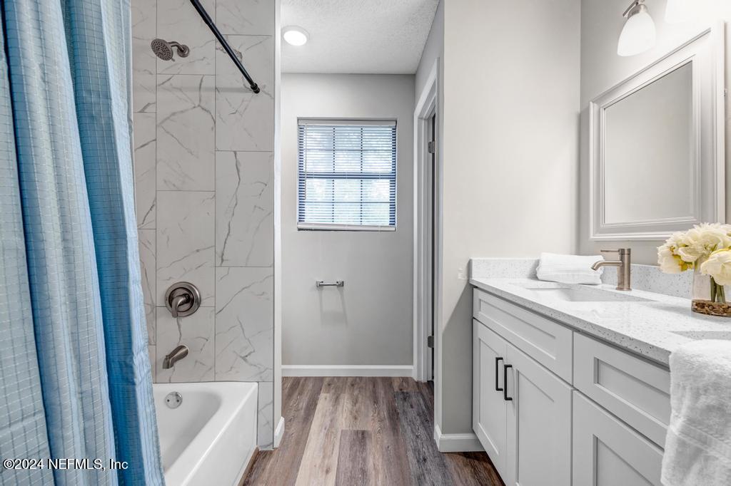 54197 Jeannie Road Callahan, FL 32011 - Photo 24 of 36 a bathroom with a granite countertop sink a toilet and shower
