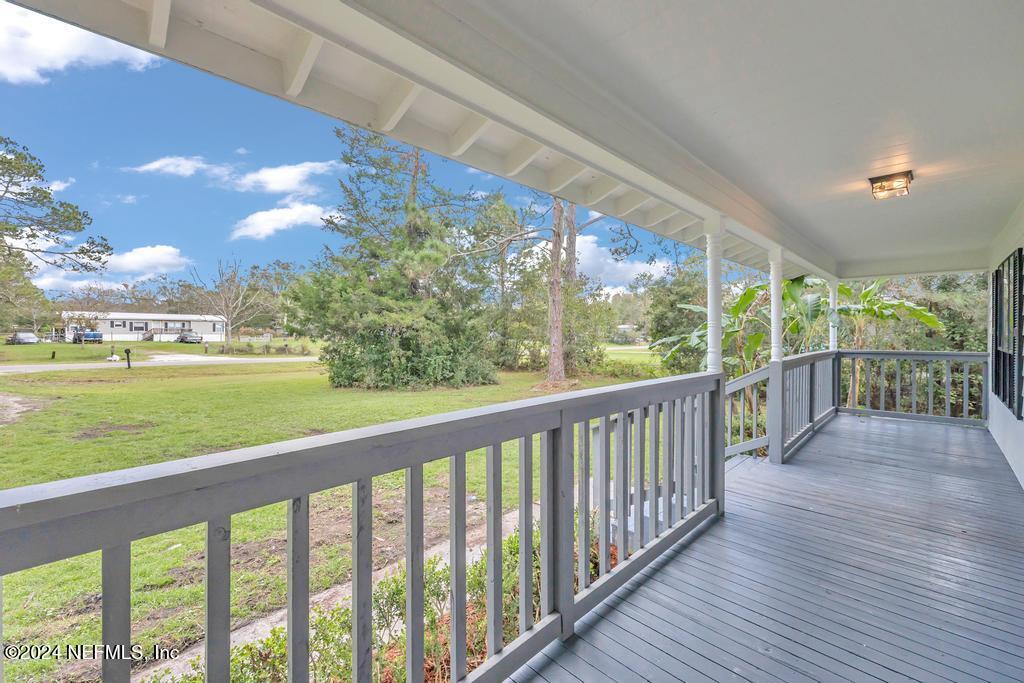 54197 Jeannie Road Callahan, FL 32011 - Photo 3 of 36 a view of a porch with wooden floor and yard in the back