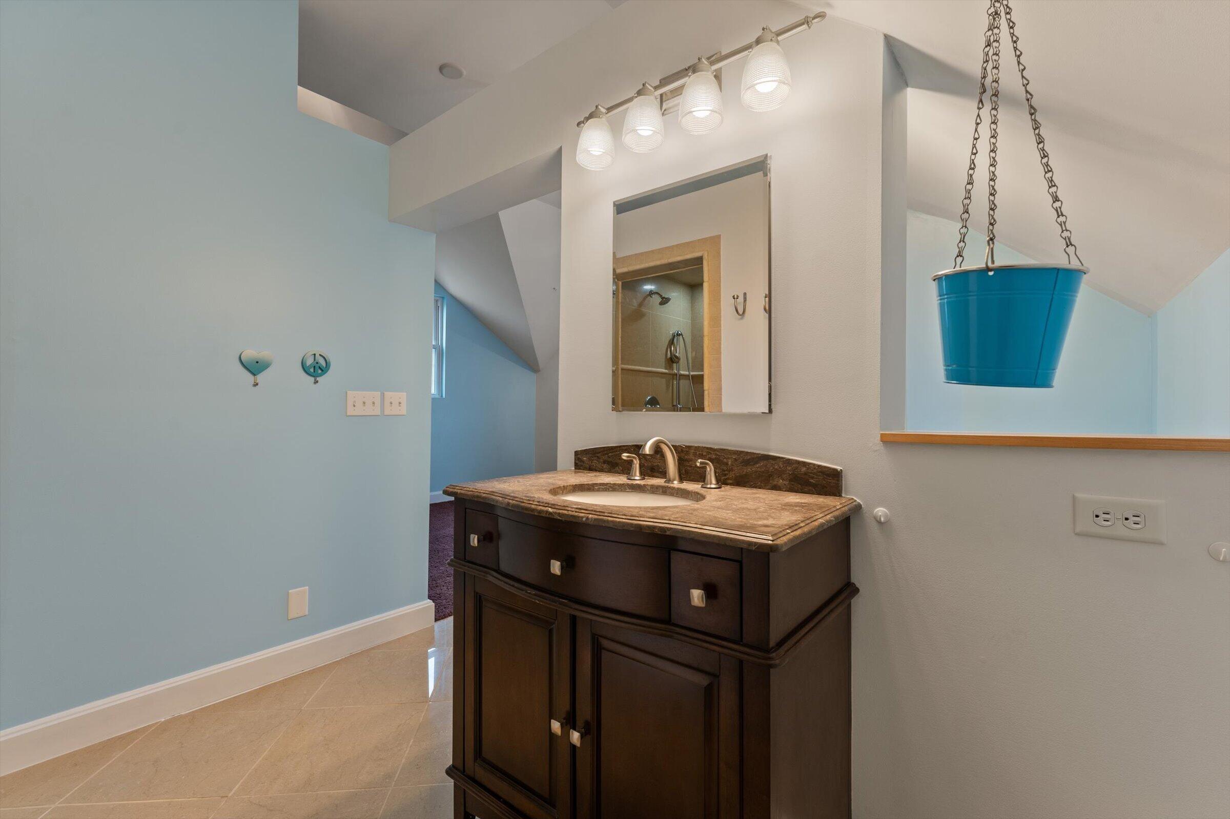 7692 North Emery Road Rolling Prairie, IN 46371 - Photo 50 of 69 a bathroom with a granite countertop sink a toilet and mirror