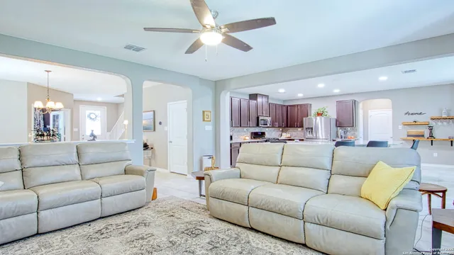 a living room with furniture white walls and a dining table with kitchen view