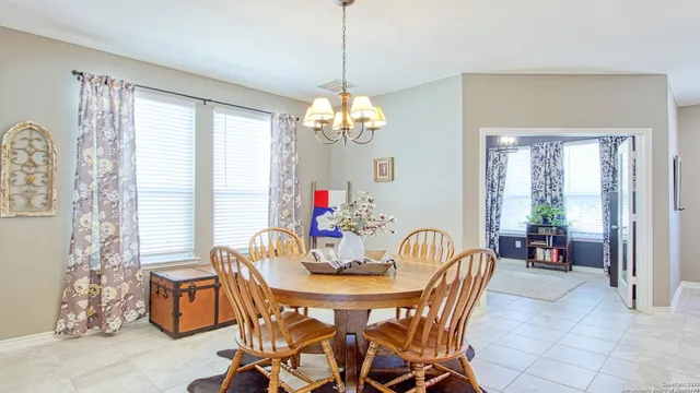 a dining room with furniture a chandelier and window