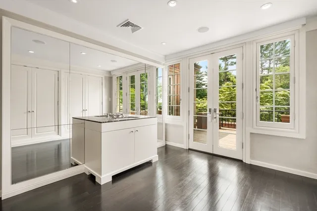 a large white room with window and wooden floor