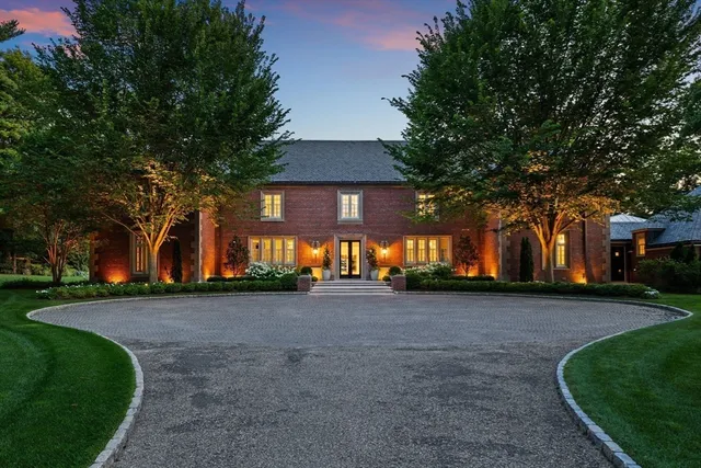 a front view of a house with a yard and tree s