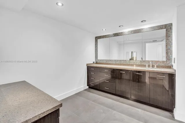 a bathroom with a sink mirror and shower