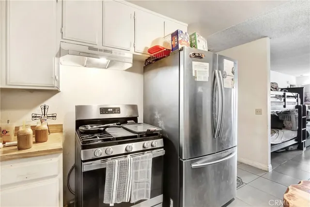 a kitchen with stainless steel appliances granite countertop a refrigerator and a stove top oven