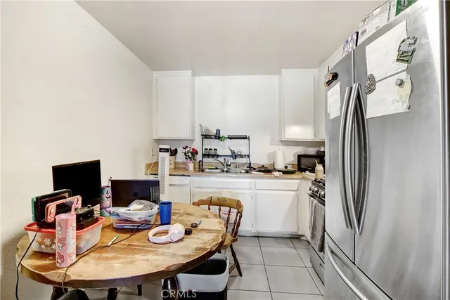 a kitchen with stainless steel appliances granite countertop a sink dishwasher a refrigerator and a stove with white countertops