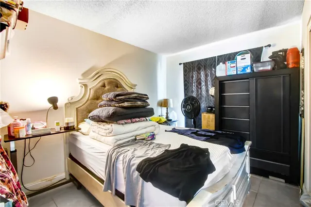 a bedroom with a bed and a lamp on the dresser