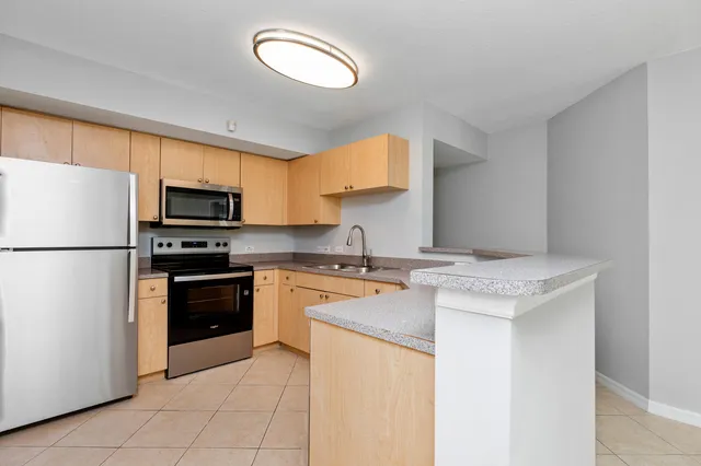 a kitchen with stainless steel appliances granite countertop a stove a refrigerator and a sink