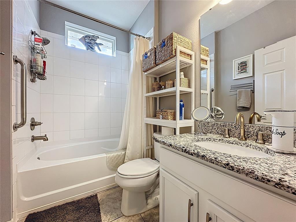 277 Silver Maple Road Groveland, FL 34736 - Photo 25 of 81 a bathroom with a granite countertop sink a toilet and shower
