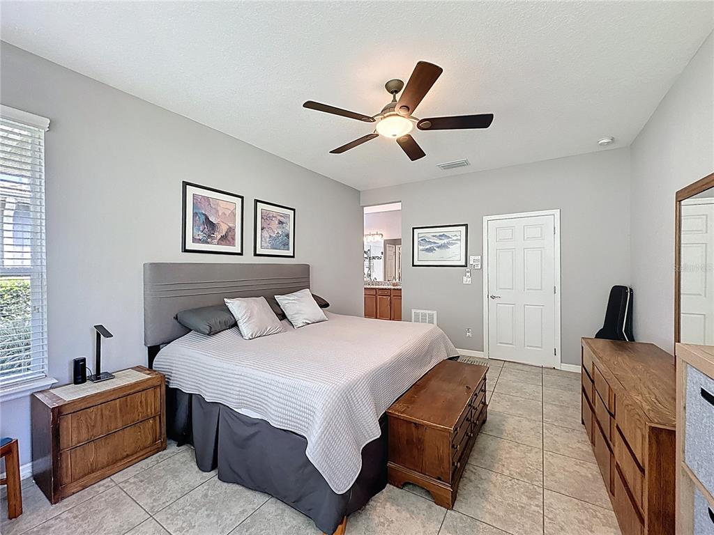 277 Silver Maple Road Groveland, FL 34736 - Photo 31 of 81 a bedroom with a large bed and a window