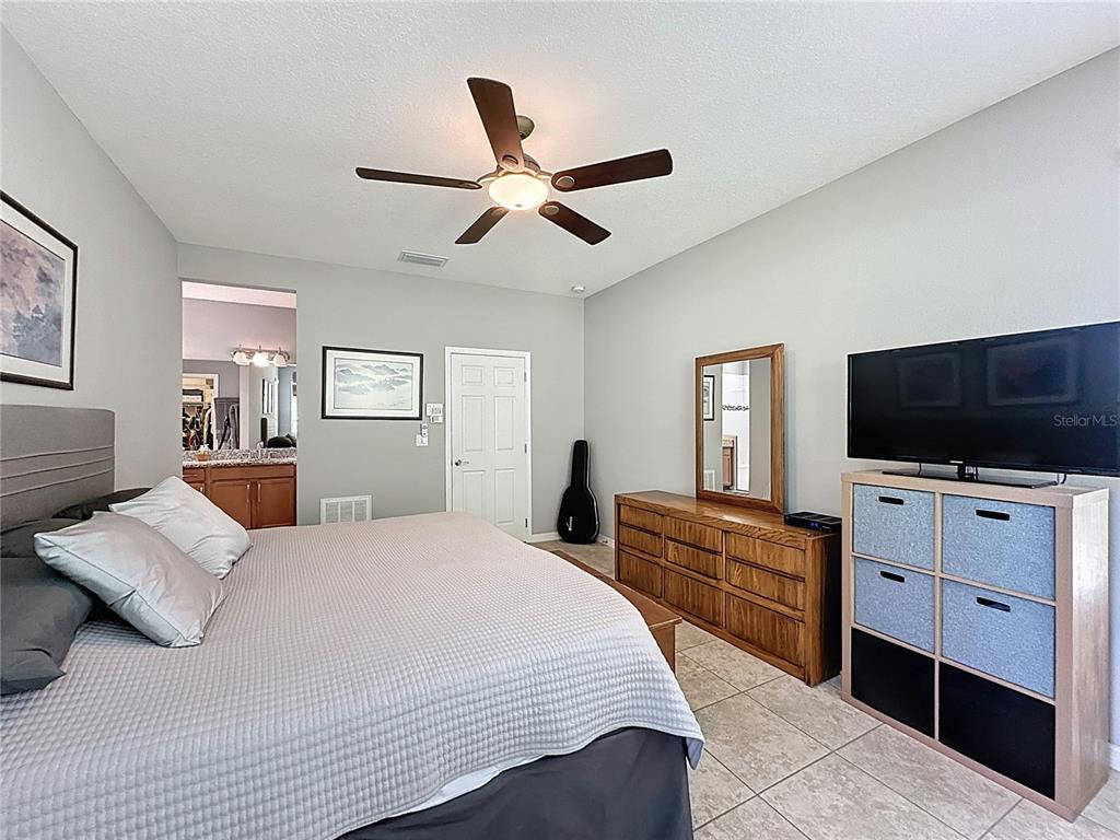 277 Silver Maple Road Groveland, FL 34736 - Photo 32 of 81 a bedroom with a bed and a flat screen tv