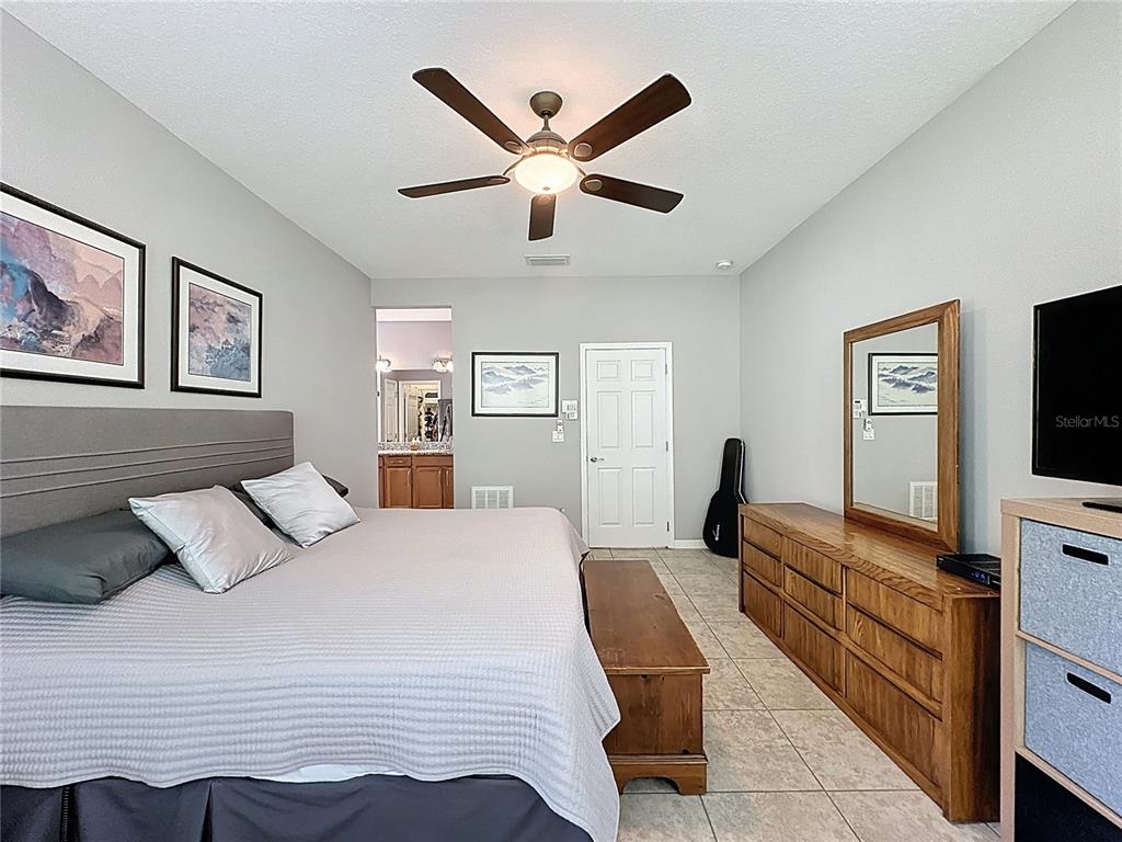 277 Silver Maple Road Groveland, FL 34736 - Photo 33 of 81 a bedroom with a large bed and a flat screen tv