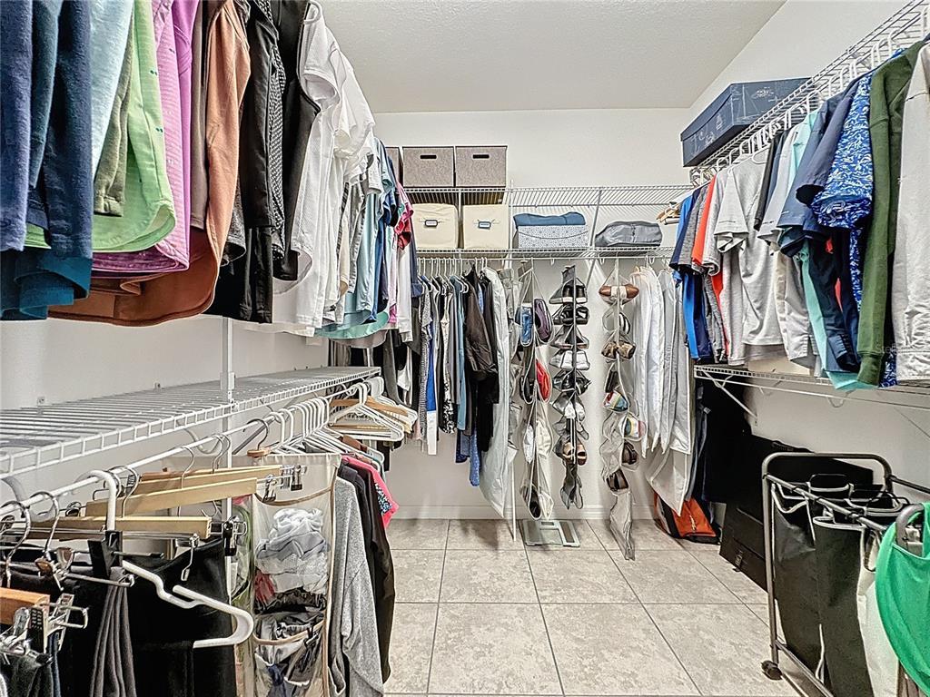 277 Silver Maple Road Groveland, FL 34736 - Photo 37 of 81 a view of walk in closet with clothes and shoes
