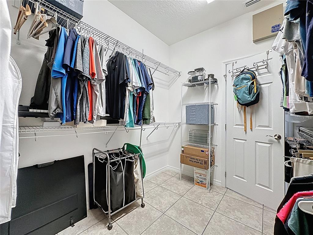 277 Silver Maple Road Groveland, FL 34736 - Photo 38 of 81 a view of walk in closet with clothes and shoes