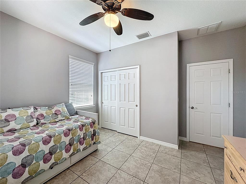 277 Silver Maple Road Groveland, FL 34736 - Photo 40 of 81 a bedroom with a bed and a chandelier fan