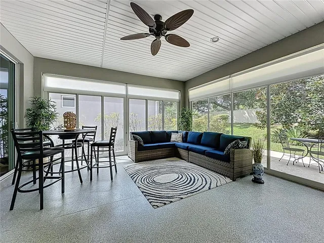 a living room with couches and kitchen view with wooden floor
