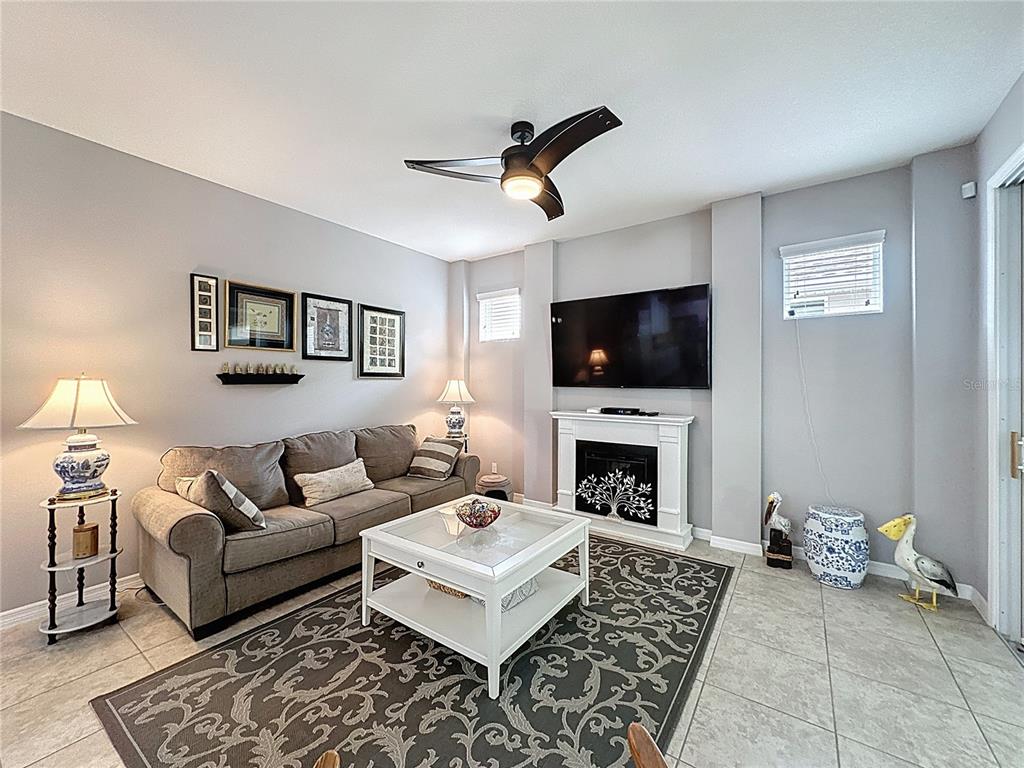 277 Silver Maple Road Groveland, FL 34736 - Photo 7 of 81 a living room with furniture a fireplace and a flat screen tv