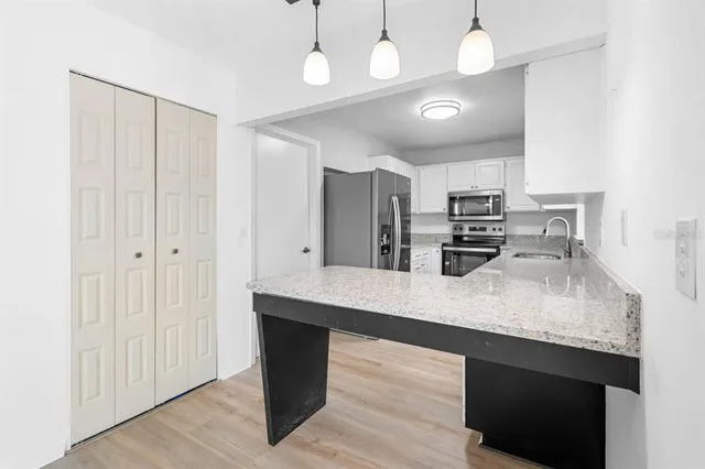 a large kitchen with a center island and stainless steel appliances