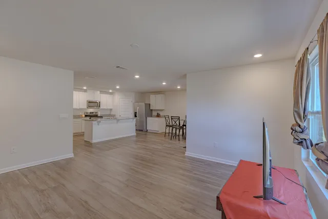 a view of a big room with wooden floor and a window