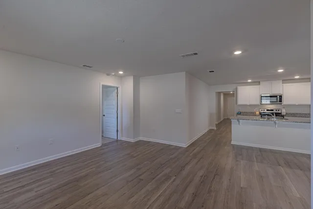 a kitchen with a sink appliances and wooden floor