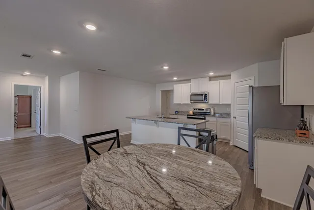 a kitchen with kitchen island granite countertop a stove sink and microwave