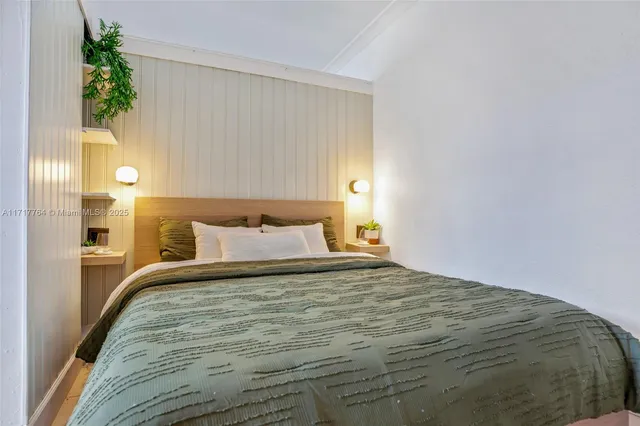 a bedroom with a bed and a potted plant