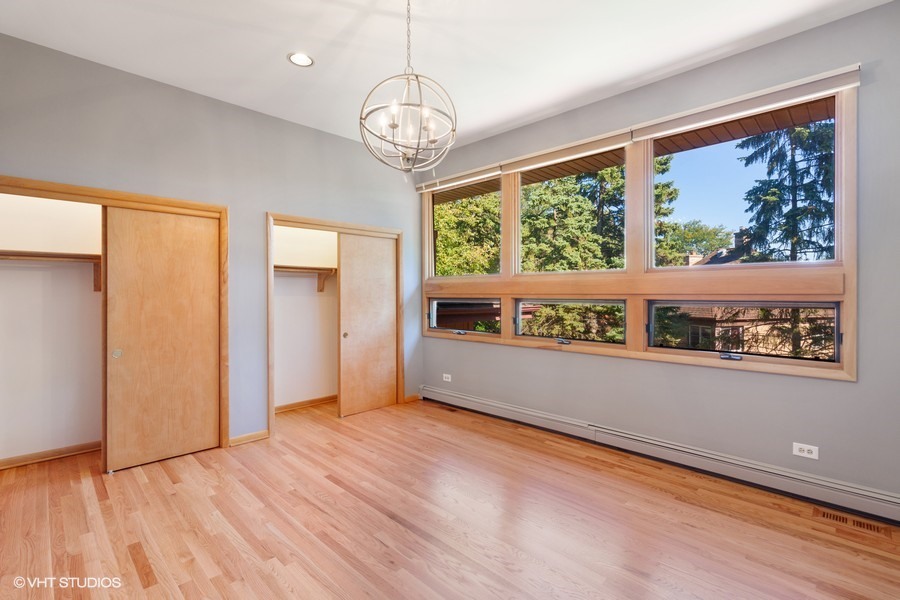 399 Audubon Road Riverside, IL 60546 - Photo 18 of 31 an empty room with wooden floor and large window